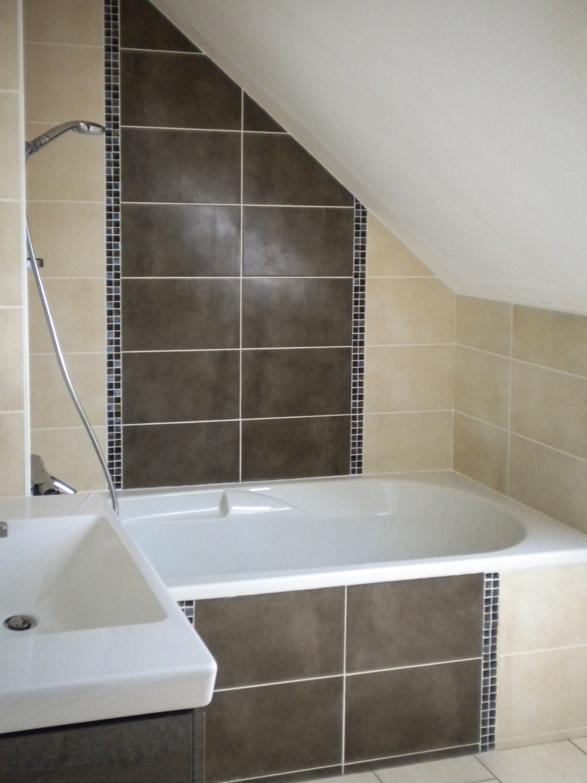 Une salle de bain sous combles avec baignoire